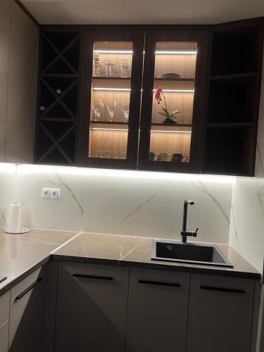 a kitchen with a sink and wine glasses at Lilly LuX Big Luxury Apartment with Free Parking and garage in Bijeljina