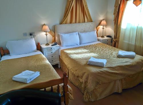 a bedroom with two beds with towels on them at Acorn Guest House in Cambridge