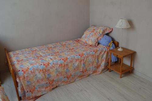 - une chambre avec un lit et une table avec une lampe dans l'établissement Etape à Villeperdue, à La Barillonnerie