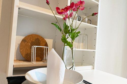 a vase with pink flowers in a kitchen at Business & Tourist Apartment with Balcony in Osnabrück