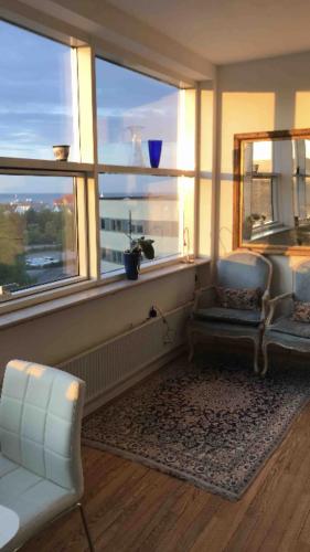 a living room with two chairs and a window at Seaview and swimming in Hellerup