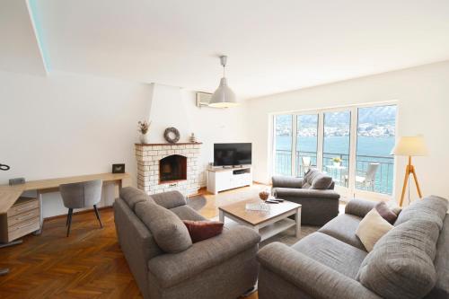 a living room with two couches and a fireplace at House 44 SEAFRONT APARTMENTS in Kotor