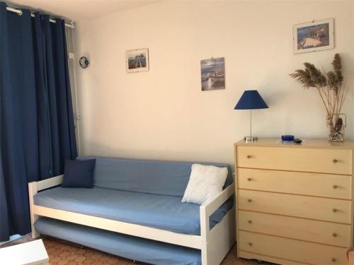 - une chambre avec un lit bleu et une commode dans l'établissement Appartement 4 pers à 50m des commerces, plage à proximité - FR-1-81-236, à Port-Leucate