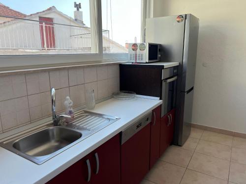 a kitchen with a sink and a refrigerator at Apartmani Kacola in Tučepi