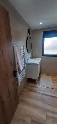 une salle de bain avec un lavabo, un miroir et une fenêtre dans l'établissement Gites Ostheim, à Ostheim