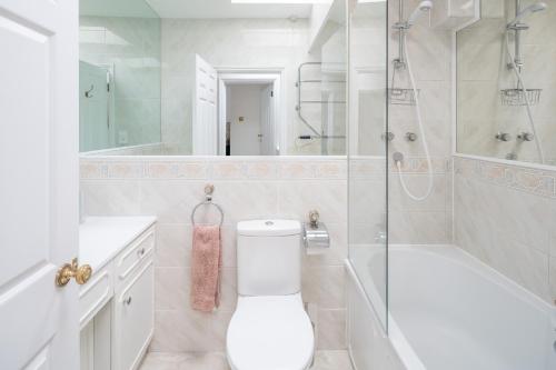 y baño con aseo, ducha y lavamanos. en JOIVY Fabulous 4BR house with terrace at the heart of Notting Hill, en Londres