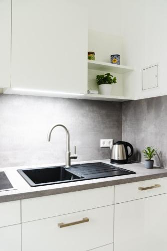 a kitchen with white cabinets and a sink at 4-Zi Urban Design 120m² BRANDNEW 200Mbit in Berlin