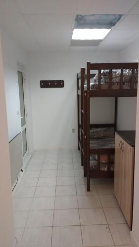 a room with two bunk beds and a tiled floor at Mister Hostel in Lviv
