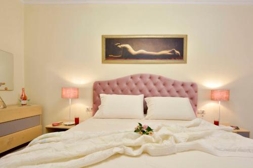 a bedroom with a large white bed with a pink headboard at Sweet Luxury House in Alepou