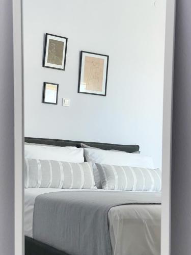a bedroom with white walls and a bed with white pillows at Amalthia Apartment Milos, Adamas Town center in Adamantas