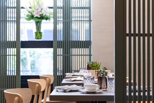 a dining room with a table with a vase of flowers at La Suite West - Hyde Park in London