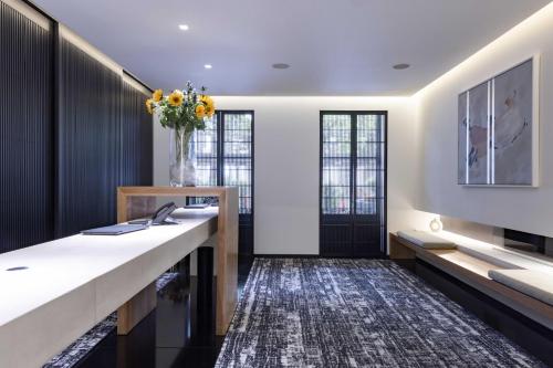 a home office with a desk and a vase of flowers at La Suite West - Hyde Park in London