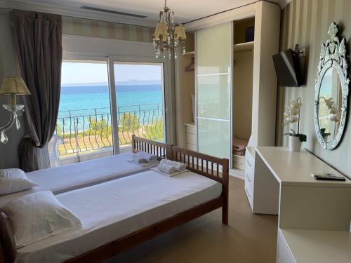 una camera da letto con un letto e vista sull'oceano di Plaza Hotel a Hanioti