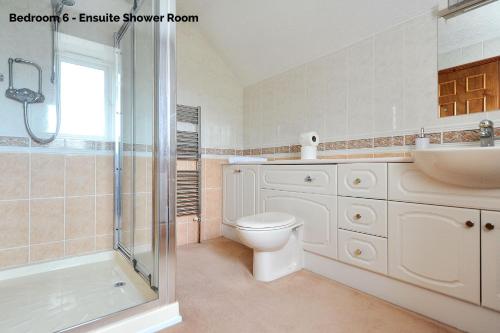 a bathroom with a shower and a toilet and a sink at Manor Lodge in Burton Bradstock