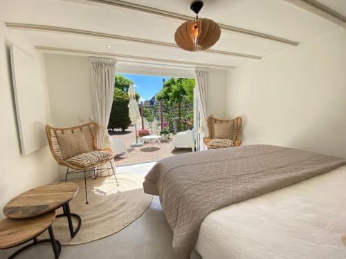 a bedroom with a bed and a chair and a window at Emma Lodge Zandvoort in Zandvoort