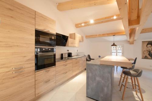 une cuisine avec des armoires en bois et une table avec des chaises dans l'établissement MAISON MARTINE, à Saint-Tropez