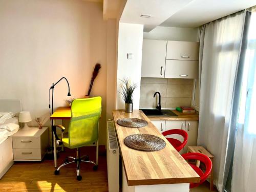 kuchnia ze stołem i żółtym krzesłem w obiekcie Victoriei studio w Bukareszcie
