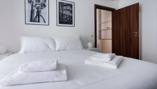 a bedroom with a white bed with two towels on it at Carlone 5 in Milan