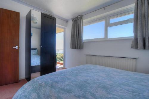 a bedroom with a large bed and a window at 38 Wessex Court in Lyme Regis