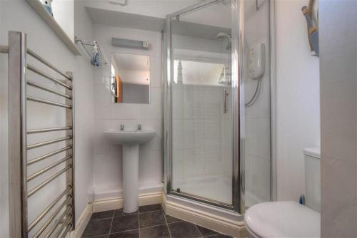 a bathroom with a shower and a sink and a toilet at 4 Bay View Court in Lyme Regis