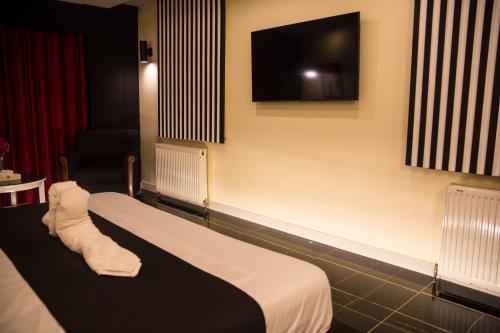 a hotel room with a bed and a flat screen tv at Metropole Hotel in Murree