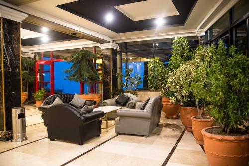 a living room with couches and potted plants at Metropole Hotel in Murree