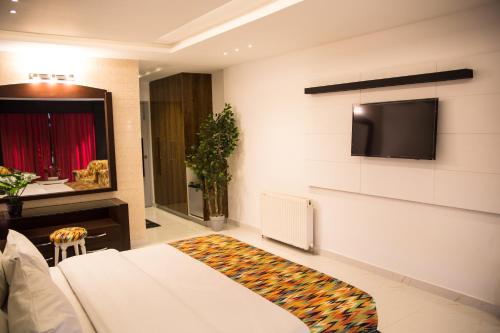 a room with a bed and a tv on a wall at Metropole Hotel in Murree