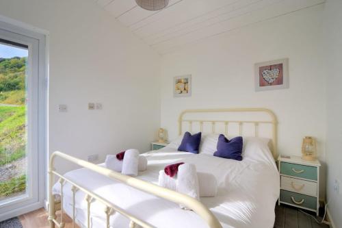 a bedroom with a white bed with towels on it at The Beach Hut in Lyme Regis