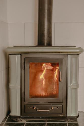 a stove with a fire in it in a kitchen at Almhaus Kochjosel in Garanas