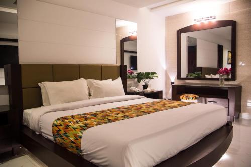 a bedroom with a large bed and a large mirror at Metropole Hotel in Murree
