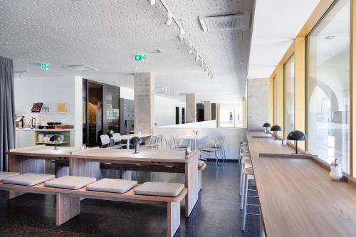 a room with benches and tables in a building at MEININGER Hotel Bremen Hauptbahnhof in Bremen