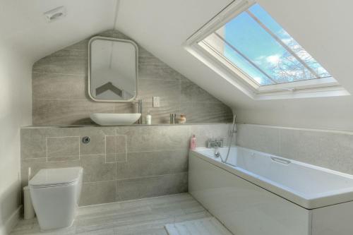 baño con bañera, lavabo y ventana en 3 Major Terrace en Seaton