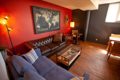 a living room with a couch and a table at Hôtel des Isles in Barneville-Carteret