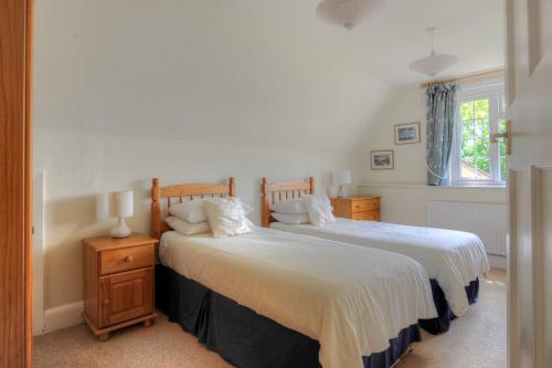 a bedroom with two beds and a window at Barn Close Farm in Morecombelake