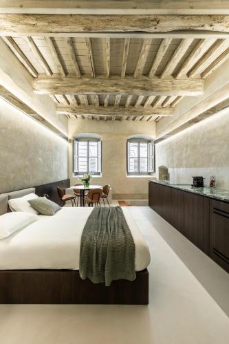 a bedroom with a large bed and a table at CHIAROMANNI SUITE in Arezzo