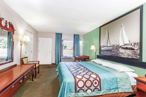 a hotel room with a bed with a picture on the wall at Super 8 by Wyndham Marianna in Marianna