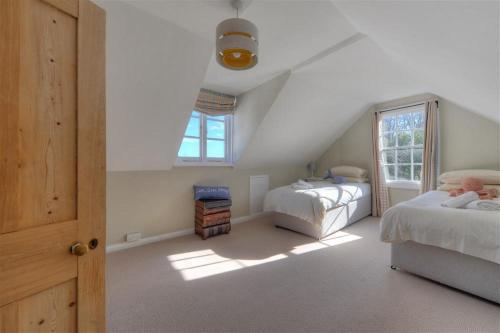 a attic bedroom with two beds and a window at The Lodge in Lyme Regis