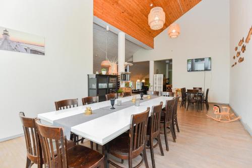 a large dining room with a long table and chairs at Skalva Nida in Nida