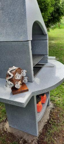 a barbecue grill with orange shoes sitting on top of it at Kod Gruja in Ribnica