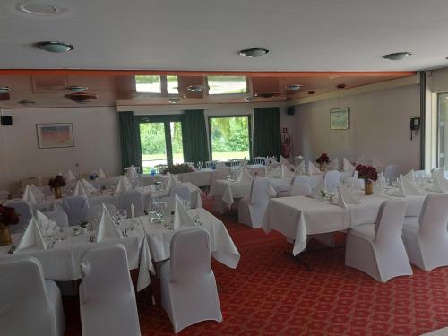a room full of tables and chairs with white table cloth at Globales Post Hotel & Wellness in Herstal