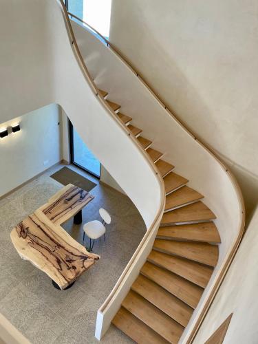 a spiral staircase in a house with a table and a stool at Domaine de Panery in Pouzilhac