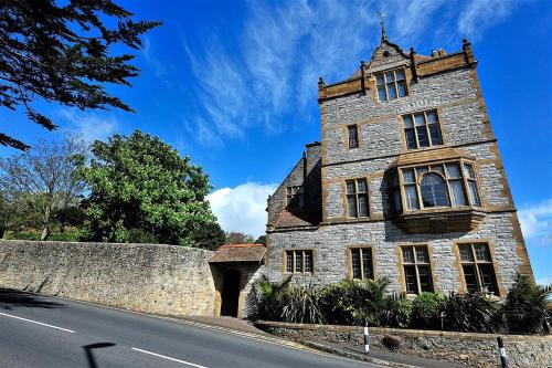 an old stone building on the side of a road at 6 Coram Tower in Lyme Regis