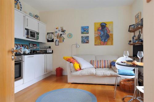 a living room with a couch and a kitchen at 6 Coram Tower in Lyme Regis