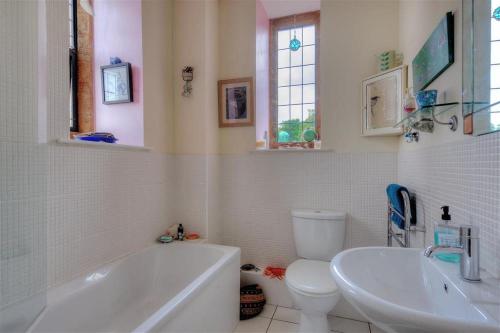 y baño con bañera, aseo y lavamanos. en 6 Coram Tower, en Lyme Regis