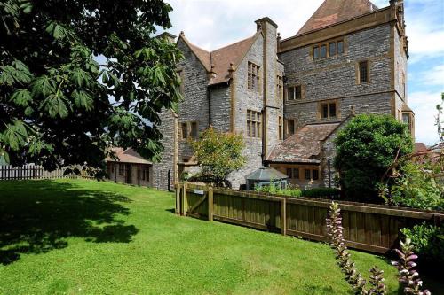 an old stone building with a fence in a yard at 6 Coram Tower in Lyme Regis