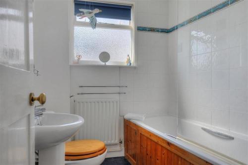 Un baño con lavabo, inodoro y bañera. en Riverview, en Lyme Regis