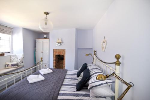 a bedroom with a bed with pillows and a fireplace at 17 Mill Green in Lyme Regis