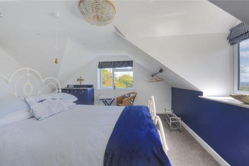 a bedroom with a blue and white bed and a window at High Bullen Cottage in Morecombelake
