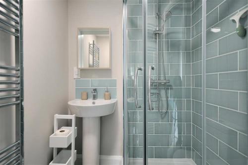 Un baño con lavabo y ducha de cristal. en Mermaid House, en Lyme Regis