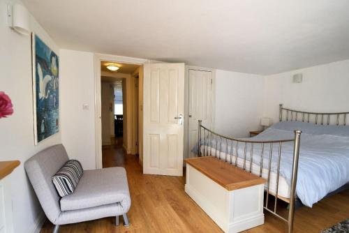 a bedroom with a bed and a chair at Little Bay View in Lyme Regis